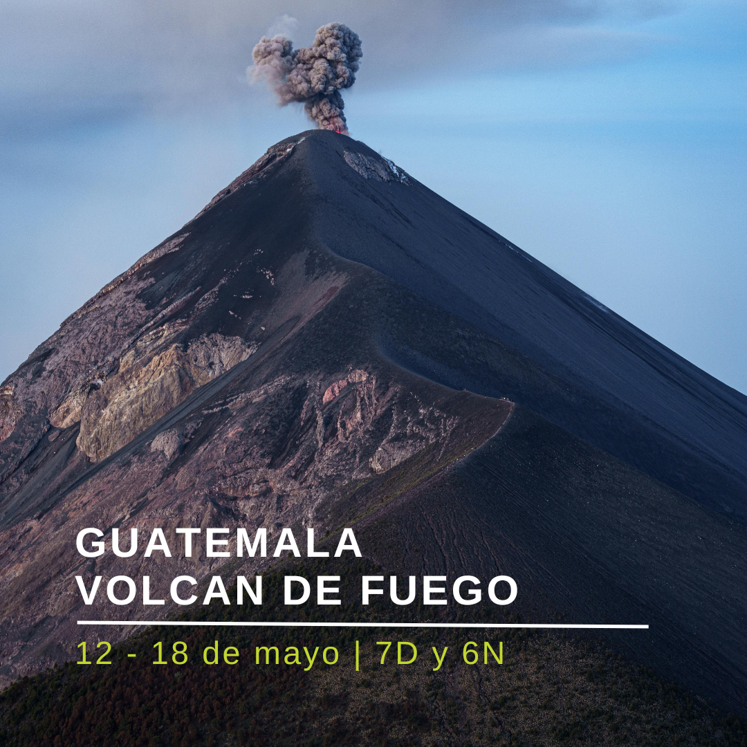 Grupo de montañistas observando una erupción leve del Volcán de Fuego al atardecer en Guatemala, viaje desde Mexico.